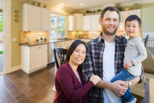 Mixed Race Chinese and Caucasian Parents and Child Indoors Inside Beautiful Custom Kitchen.