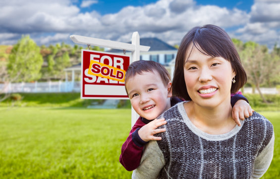 Chinese Mother and Mixed Race Child In Front of Custom House and Sold For Sale Real Estate Sign.
