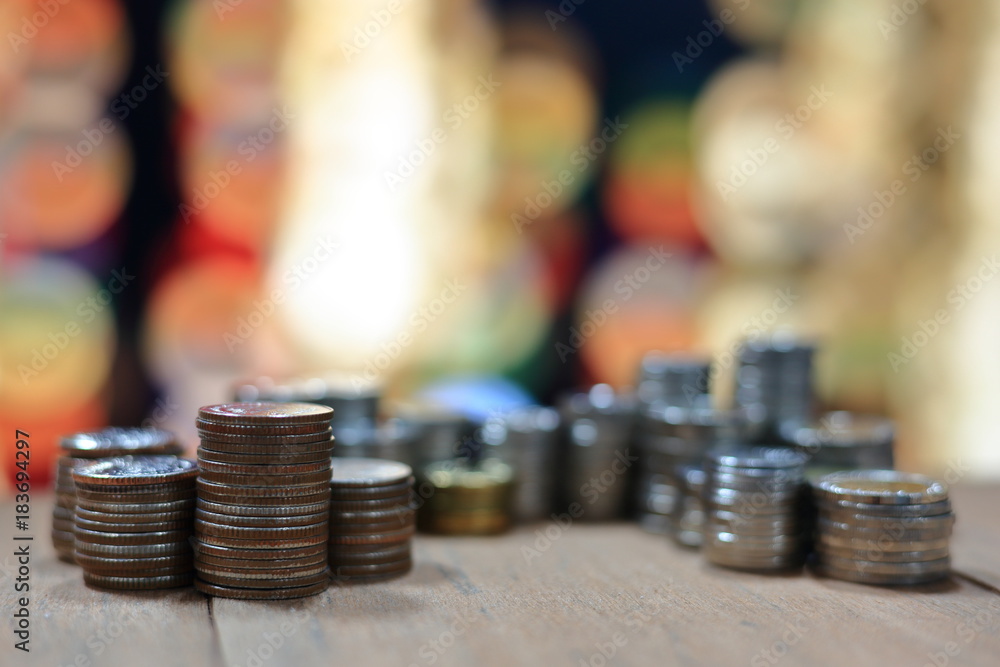 Poster increasing chart made of coins. coin stacked in to tower on a wooden board. soft light red bokeh bac