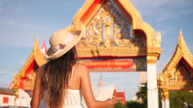 Young Mixed Race Tourist Girl Walking with Map in Thai Buddhist Temple. Phuket, Thailand. 4K, Slowmotion.