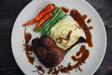 duck confit , Grilled duck steak with carrot and asparagus on wood background