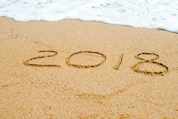 Inscription 2018 on the sand on the sea shore 