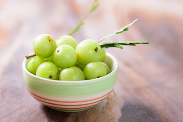 Indian gooseberry fruit in a bowl on wooden background.Healthy and highest vitamin C fruit
