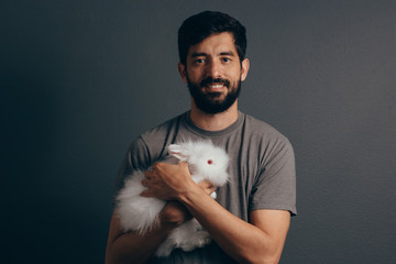 Adorable bunny in hands. Cute pet rabbit being cuddled by his owner. Concept of love for animals