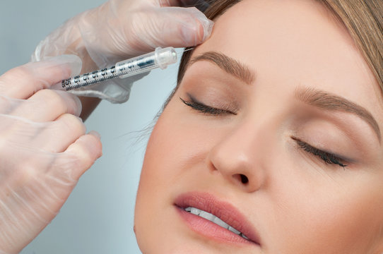 Woman is getting injection over eyebrow. Anti-aging treatment and face lift. Cosmetic Treatment and Plastic Surgery