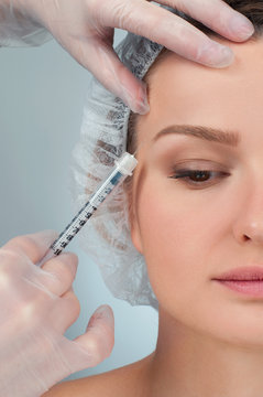 Woman is getting injection over eyebrow. Anti-aging treatment and face lift. Cosmetic Treatment and Plastic Surgery