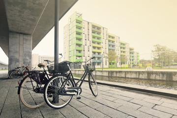 Obraz premium Пара велосипедов на берегу канала под бетонной опорой в Копенгагене. Дания