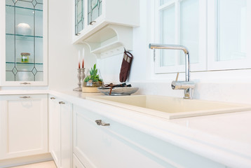 Modern, bright, clean kitchen interior with stainless steel appliances in a luxury apartment.