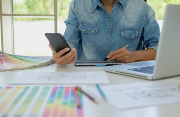 Graphic design and color swatches and pens on a desk. Architectural drawing with work tools and...
