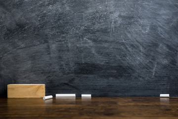 Empty blackboard or chalkboard with eraser and chalk on the table