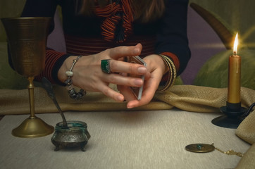 Tarot cards on fortune teller desk table. Future reading. Woman fortune teller holding in hands a deck of tarot cards and shuffles it.