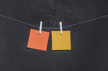 Bright colored stickers on a rope on a dark background with free copy space