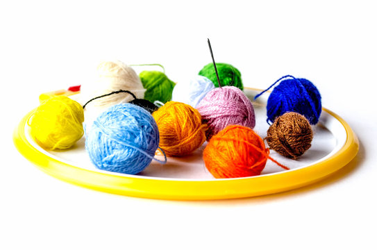 Woolen balls of yarn, tambour and embroidery. Subjects for needlework. Balls of yarn and knitting needles. Embroidery frame, thread reels for embroidery.