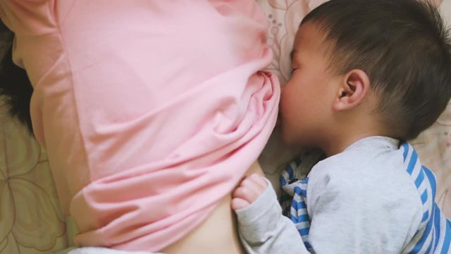 Asian boy about 1 year and 11 months old Asian baby breastfeeding before wake up in the morning
