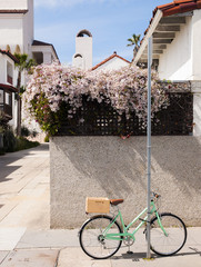 A bike with a wood basket chained to a pole in Santa Barbara, California. - obrazy, fototapety, plakaty