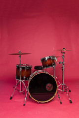 Fototapeta na wymiar Drum set on a red studio background