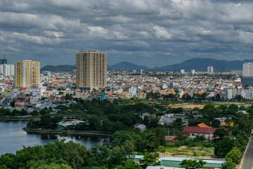 Obraz premium Landscape view from the top, lake, hills, buildings and cloudy sky. Vung Tau, Vietnam.