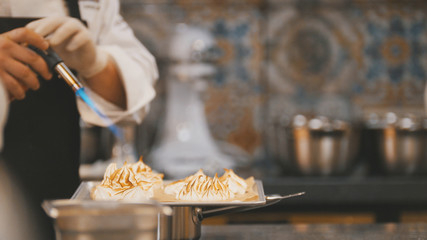 Cooking of meringue - chef use fire for decorates dessert