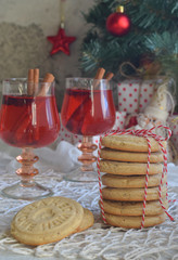 Christmas and new year holiday celebration concept background. Glass of mulled wine with spices, homemade cookie, xmas tree decoration on wooden table