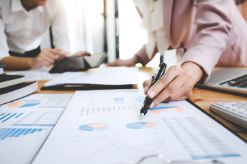 Business women analysis investment perform data document and calculating a valuation number