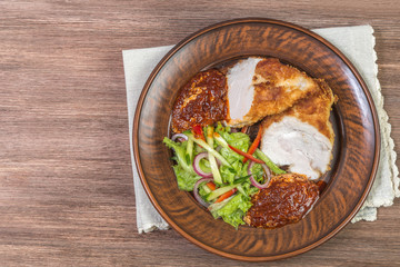 Chicken breast with Parmesan cheese, salad and tomato sauce in ceramic bowl closeup. The view from the top. Space to insert text
