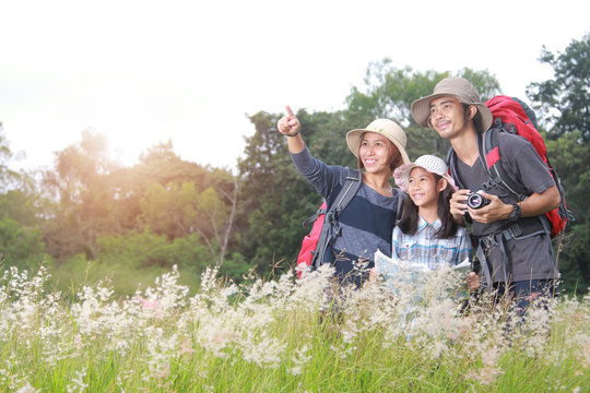 Happy Asian Family Backpack Travel Standing Near The Meadow At The Day Time. Concept Of Friendly Family.