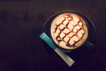 Hot coffee on wooden saucer on wooden table