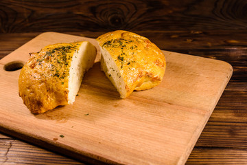 Italian bun ciabatta with garlic on wooden table