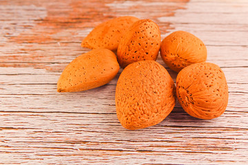 Whole almond on white rustic wood background