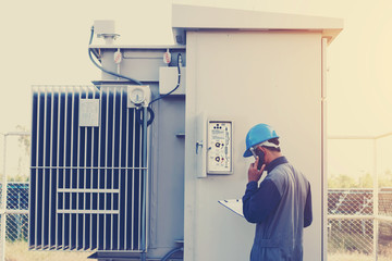 engineer or electrician working on checking status step up transformer high voltage on transformer yard and solution problem to operate at green energy solar power plant.