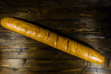 French white baguette on a wooden table. Top view