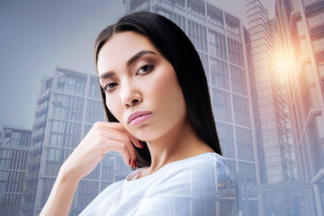 Fototapeta premium Attentive manager. Professional enthusiastic smart manager of a big company standing with her hand near the face and feeling disappointed with the lazy employees