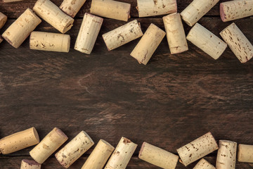 Wine corks on dark wooden texture, frame with copyspace