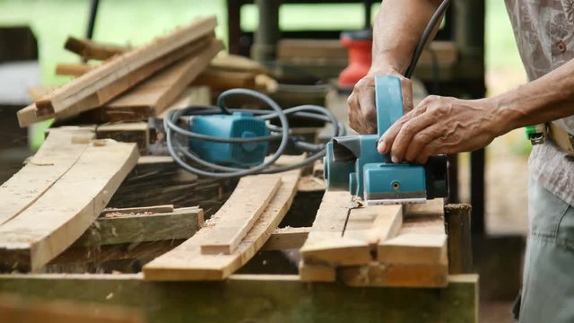 Closeup Carpenter Using Electric Plane Planing Wooden Plank