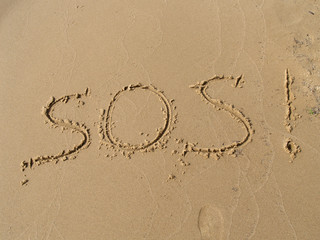 Inscription  SOS   on a sandy beach