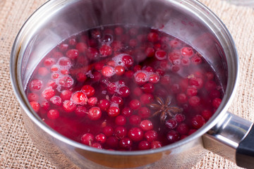 Cranberries in a sautepan with spices. Hot drink