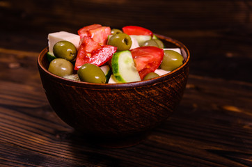 Greek salad in a bowl on wooden table