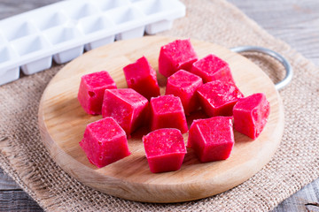 Frozen berry cubes on a cutting board