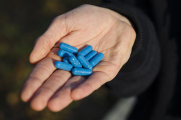 guy is holding a pill