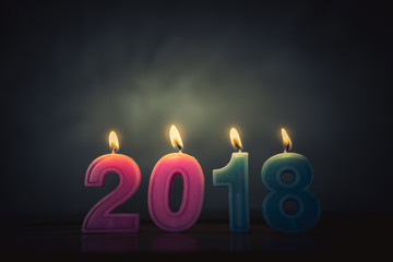 Happy new year 2018. Frame and candles numbers on wood table. 
