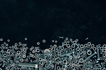 flat lay with arranged metal screws and clinchers with copy space on dark surface