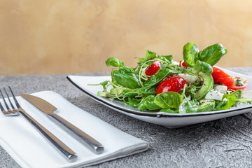 salad with avocado, mozzarella, Basil and cilantro in a beautiful plate stands on the table