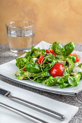 salad with avocado, mozzarella, Basil and cilantro in a beautiful plate stands on the table