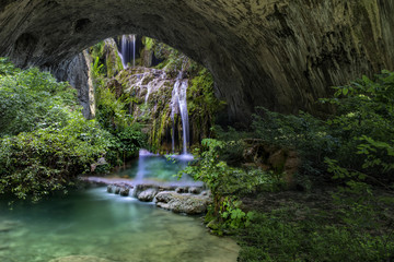 cave entrance with trees and river inside