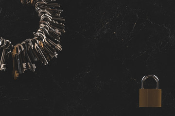 top view of heap different metal keys with lock isolated on black