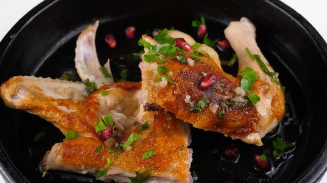 Chicken roasted in pan, served with pomegranate grains and spices in black clay dish, 4K, ProRes codec, 422 HQ