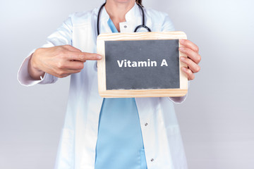 Arzt mit Schild zu Vitaminen 