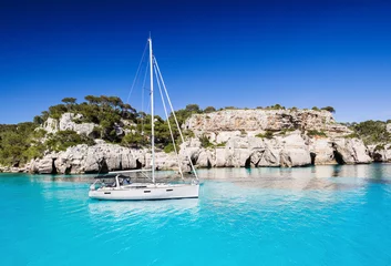 Fotobehang Beautiful bay in Mediterranean sea with sailing boat, Menorca island, Spain © kite_rin