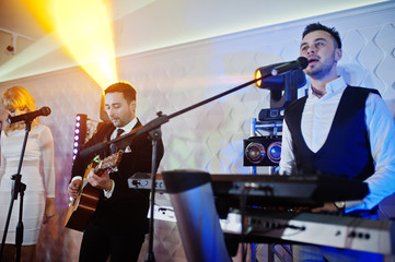 Fototapeta premium Musicial music live band performing on a stage with different lights.