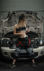 Obraz na płótnie Canvas girls in the way mechanics repair cars